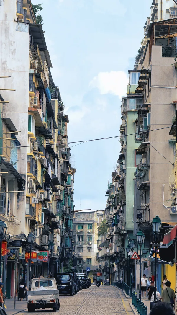 Narrow cobblestone street lined with tall apartment buildings